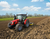 Tractor SAME trabajando la tierra en un amplio campo abierto